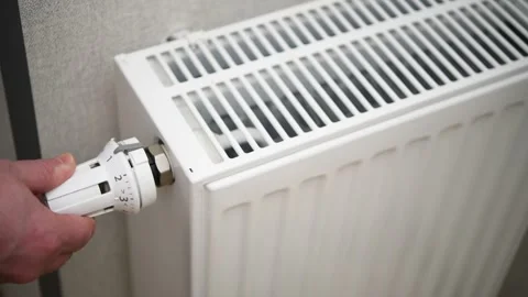 A man adjusts the temperature on a heating radiator in an apartment. Stock Footage 300080949
