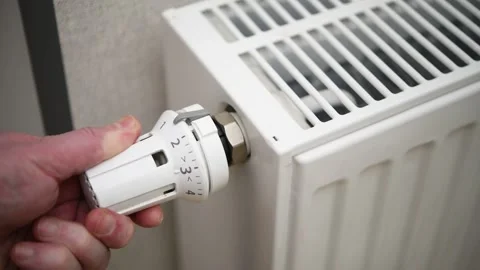 A man adjusts the temperature on a heating radiator in an apartment. Stock Footage 300081039