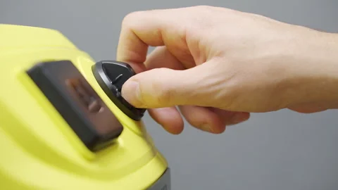 A man adjusts the vacuum cleaner's operating mode before cleaning Stock Footage 290799980