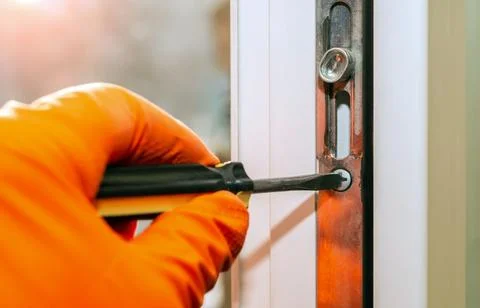 Man adjusts the window with screwdriver. Do it yourself concept. Stock Photos