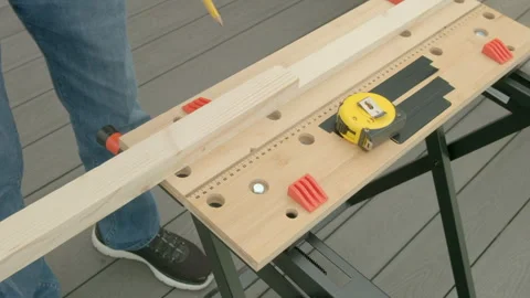 Man adjusts wood on workbench with tape measure Stock Footage 342055100