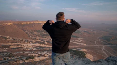 A man admires a beautiful view while traveling in a canyon Stock Footage 128580741