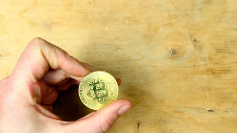 Man admiring a gold Bitcoin close up  Stock Footage 85680661