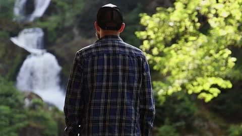 Man admiring a mountain waterfall. Stock Footage 254916141