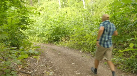 Man afraid and run away from persecution in the open air in the forest. Stock Footage 65454521
