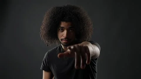 Man with afro pointing finger at camera Stock Photos