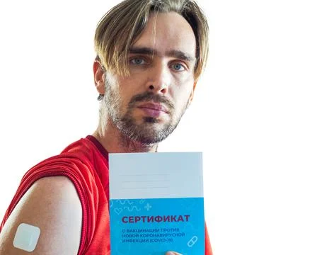 A man after vaccination with a patch pasted on his shoulder holds a vaccinati Stock Photos