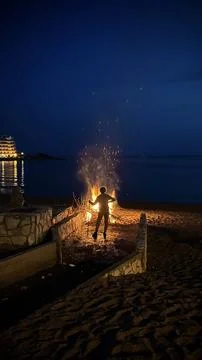 Man against the backdrop of a big fire at night Stock Photos
