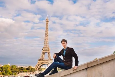 A man against the backdrop of the Eiffel tower in Paris, France. Stock Photos