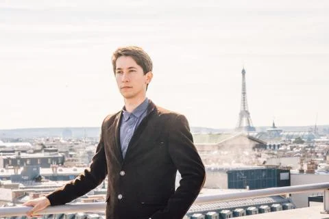 A man against the backdrop of the Eiffel tower in Paris, France. Stock Photos