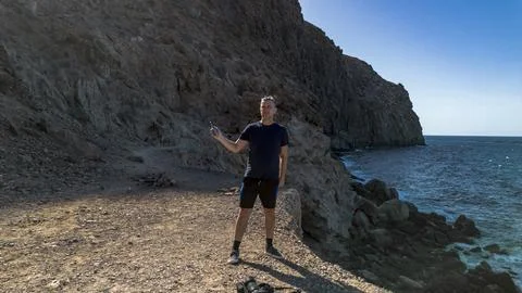 A man against a backdrop of steep cliffs and the Atlantic Ocean. Tererife, .. Stock Photos