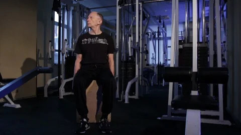 A man of the age performs joint gymnastics for the neck in the gym.Sideways head Stock Footage 115199603