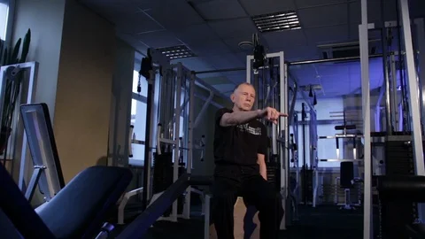 A man of the age performs joint gymnastics for all body in the gym.Index finger Stock Footage 115200216