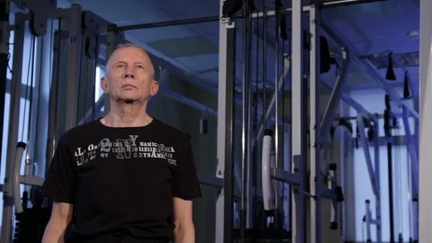 A man of the age performs joint gymnastics for the shoulders in the gym.Shoulder Stock Footage 115201478