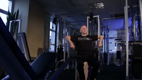 A man of the age performs joint gymnastics for the arms in the gym.Forearms Stock Footage 115207769