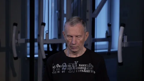 A man of the age performs joint gymnastics for the neck in the gym.Tilts head Stock Footage 115505829