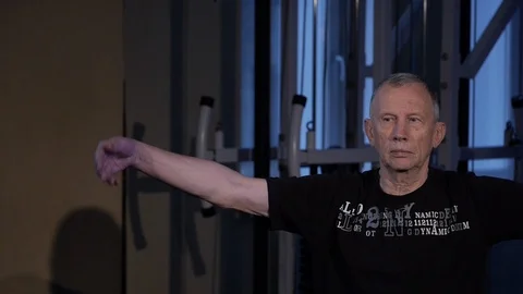 A man of the age performs joint gymnastics for the wrist in the gym.wrist Stock Footage 115510060