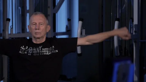 A man of the age performs joint gymnastics for the arms in the gym.forearms Stock Footage 115510592