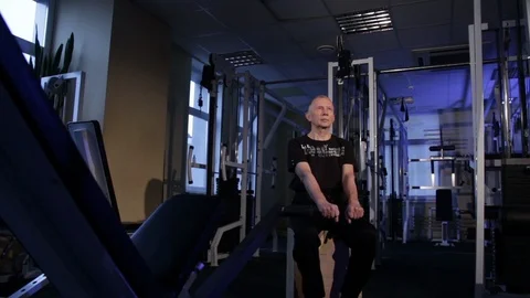 A man of the age performs joint gymnastics for the fingers in the gym.Clenching Stock Footage 115872566