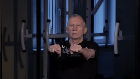 A man of the age performs joint gymnastics for the fingers in the gym.Clenching Stock Footage 115874996