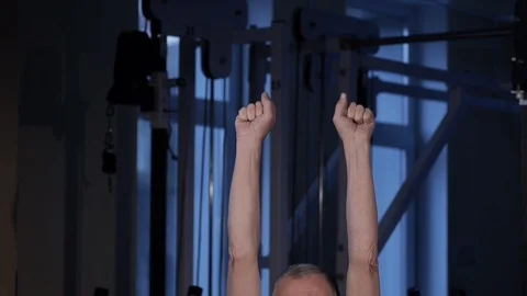 A man of the age performs joint gymnastics for the fingers in the gym.Clenching Stock Footage 115876790