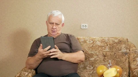 The man at the age of the tablet communicates with relatives on the internet. He Stock Footage 71244975