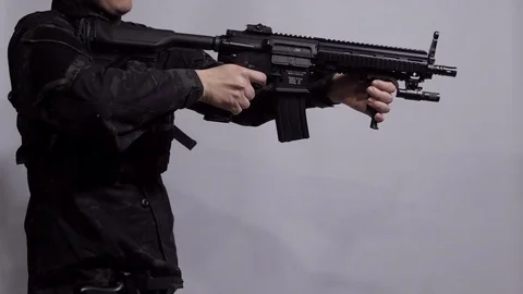 A man aiming with submachine gun and then aiming with a pistol Stock Footage 119082980