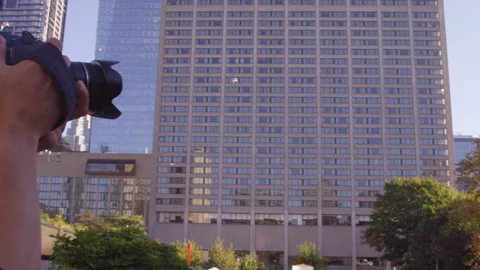 Man aims camera at buildings - panning - slow motion - shot on RED Stock Footage 123441903