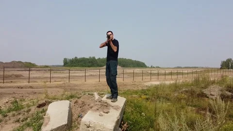 A man aims to shoot a rifle at a flying drone outdoors. Video 360. 스톡 동영상 228072007