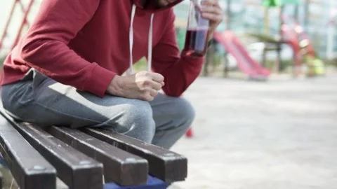 A man with an alcohol addiction throws a bottle of wine into the trash. Stock Footage 314834863