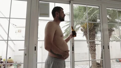 Man with alcohol problems stands in  morning, drinking beer from a bottle o.. Stock Footage 270948534