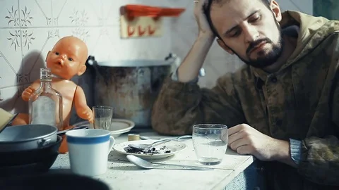 The man is an alcoholic sitting at a table and smokes Stock Footage 81815136