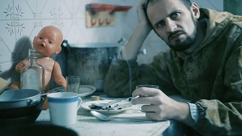 The man is an alcoholic sitting at a table and smokes Stock Footage 81815483