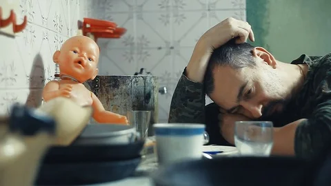 The man is an alcoholic sitting at a table and smokes Stock Footage 81856503