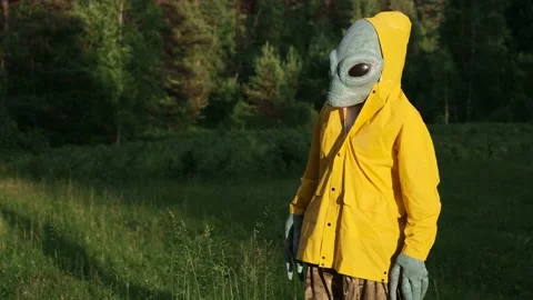 Man in an alien costume stands in forest and looks around Stock Footage 142129972