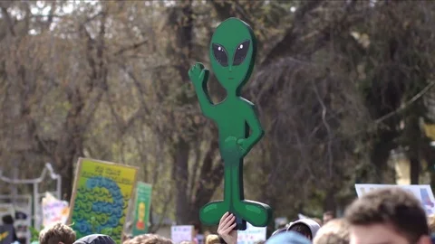 A man with an alien in his hands at a rally. The alien is on strike. Video stock 75237240