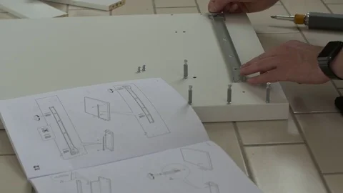 Man aligns pieces of flat pack furniture Stock Footage 71421655