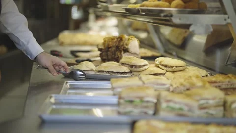 Man alligning the selection of freshly made sandwiches arranged neatly on tra Stock Footage 305946266