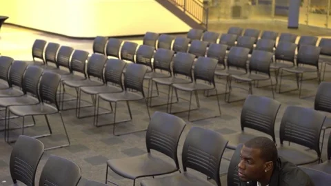 Man alone in crowd of chairs thinking 4k 스톡 동영상 73601813