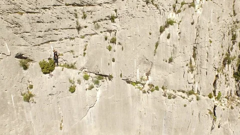 Man alone on the middle of a very high cliff, climbing in free solo Video stock 100551347