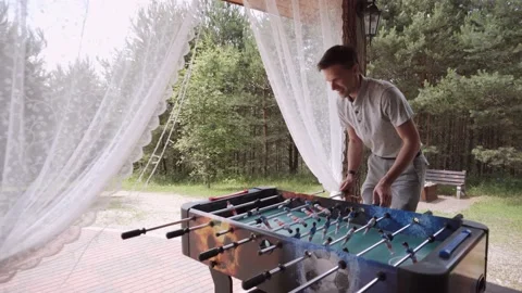 Man alone playing kicker outdoors on terrace on summer day. Stock Footage 183981730