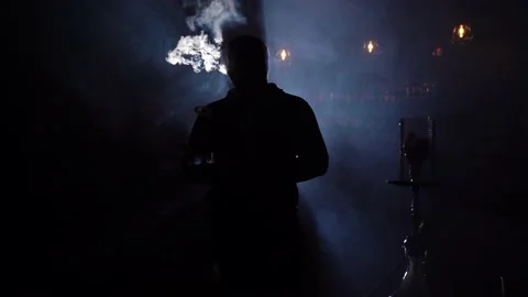 Man  alone smokes hookah exhaling clouds smoke. Rest in hookah bar Stock Footage 149240973