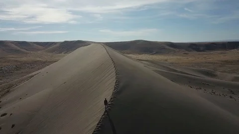 Man Alone Walking Through The Desert Drone Stock Footage 99070448