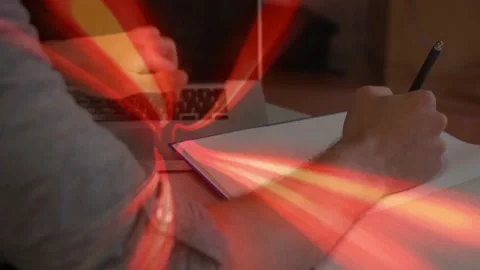 Man alternating typing and writing at desk for tech work, laptop taps causing Stock Footage 331789129
