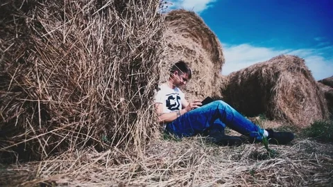 Man among many haystacks working in a laptop Stock Footage 72923379