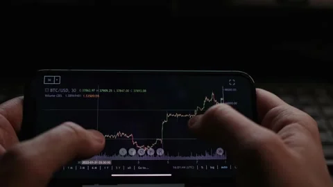 Man analyse trading graph bitcoin dollar on the phone Stock Footage 229503025