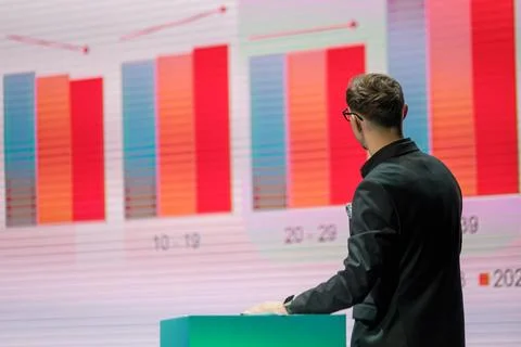Man Analyzing Bar Chart Presentation on Large Screen Stock Photos