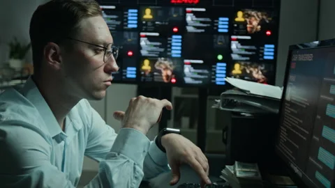 Man Analyzing Cyber Security Data on Multiple Computer Screens Stock Footage 346692717