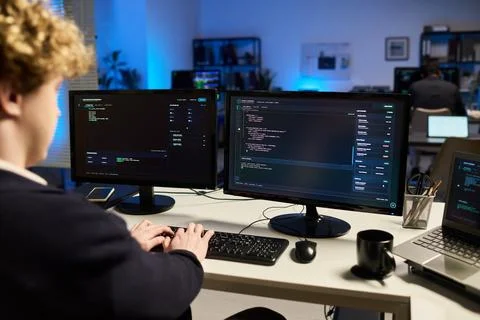 Man Analyzing Cybersecurity Code on Multiple Monitors in Office Stock Photos