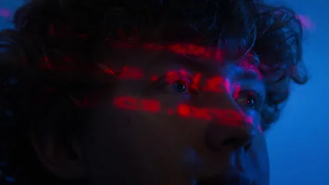 Man Analyzing Cybersecurity Code with Red Data Reflection on Face Stock Footage 347318348